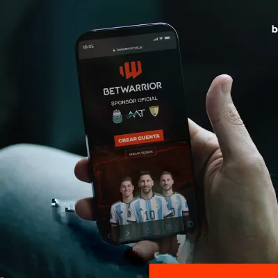 App de betwarrior de Apuestas deportivas y casino online Mano sosteniendo celular con la app de apuestas de betwarrior